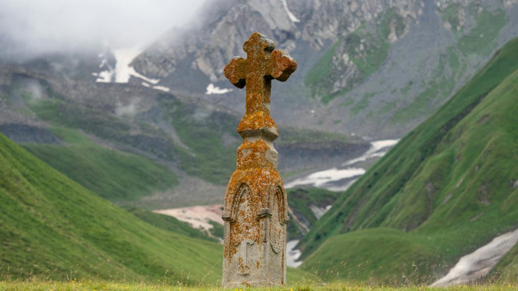 Каменный, христианский крест среди горных вершин