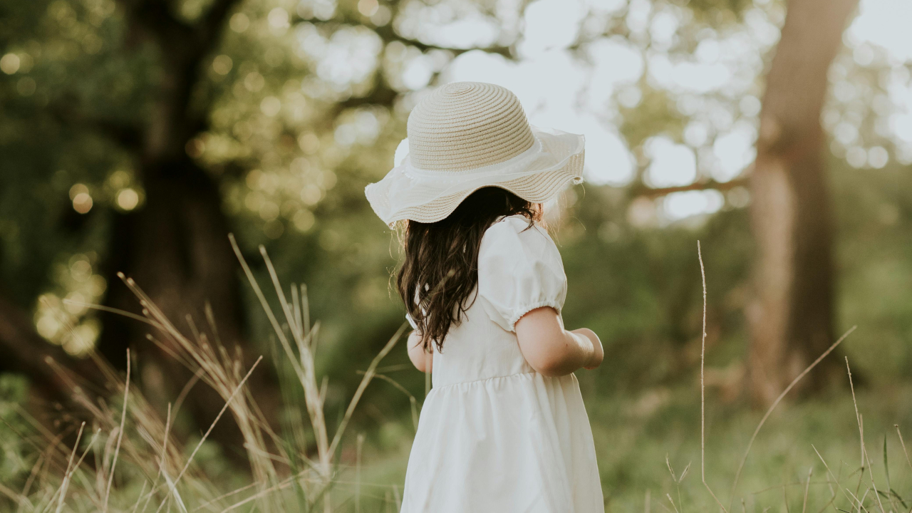 Девочка в белой одежде и шляпе, в саду