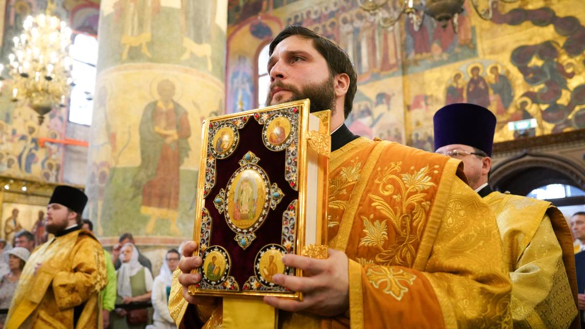 Дьякон держит в руках Евангелие