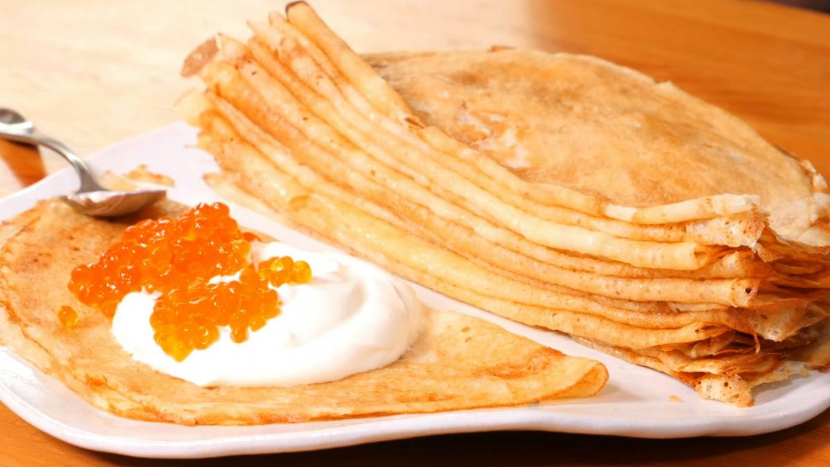 Стопка блинов со сметаной и красной икрой