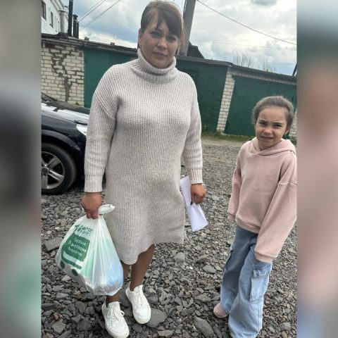 Женщина с девочкой стоят на улице