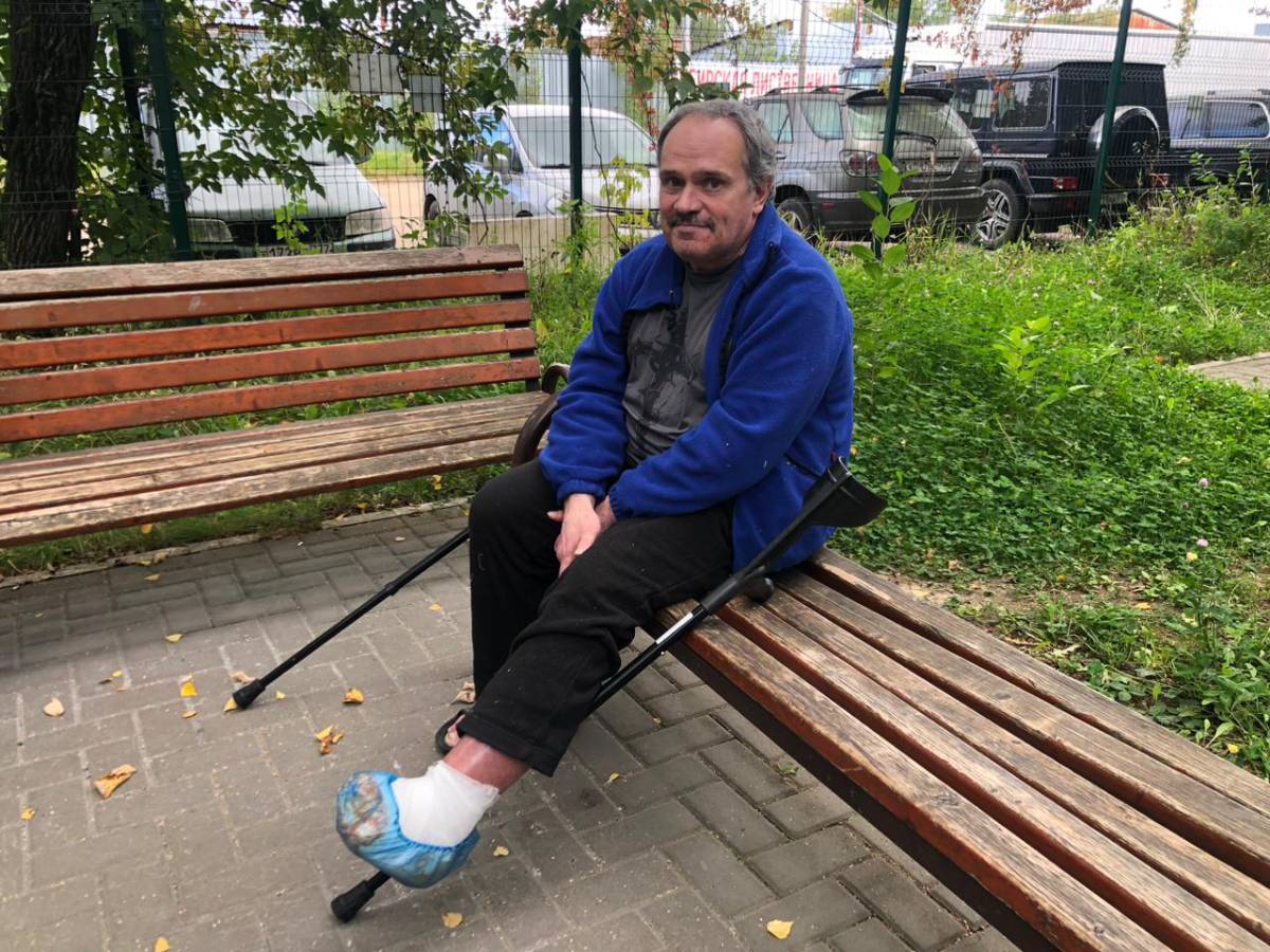 Мужчина с забинтованной ногой сидит на скамейке