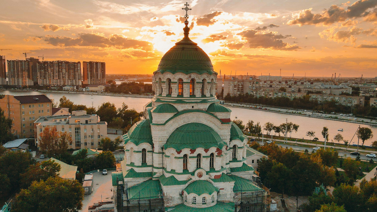 Красивый белокаменный храм с зелёными куполами