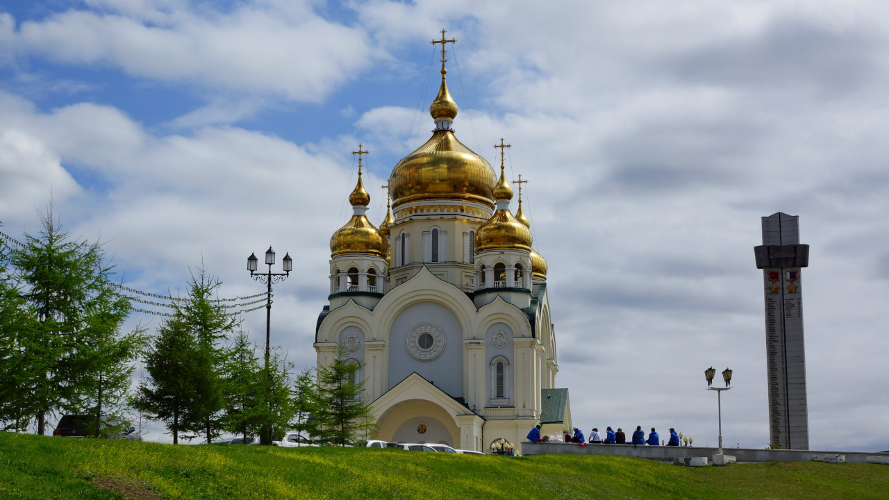 Белокаменный храм с золотыми куполами, на фоне неба
