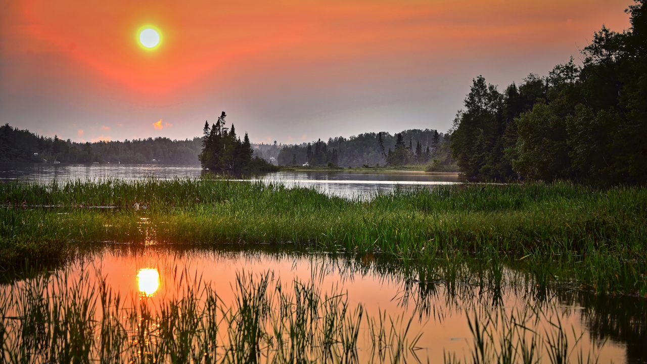 Закатное солнце отражается в реке