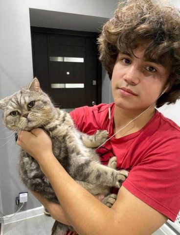 Подросток держит на руках кота