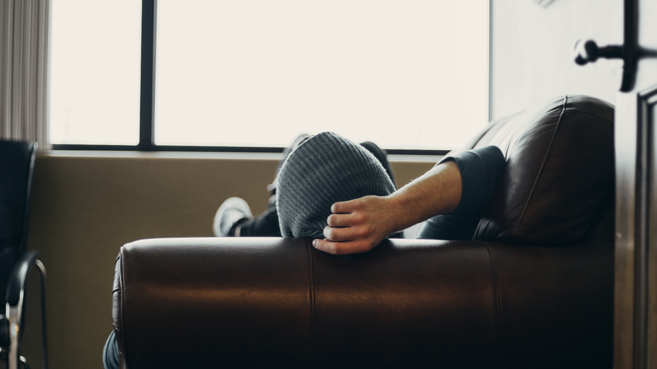 Парень лежит на кожаном диване