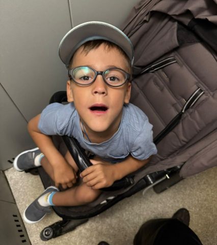 Мальчик в кепке и очках смотрит в объектив