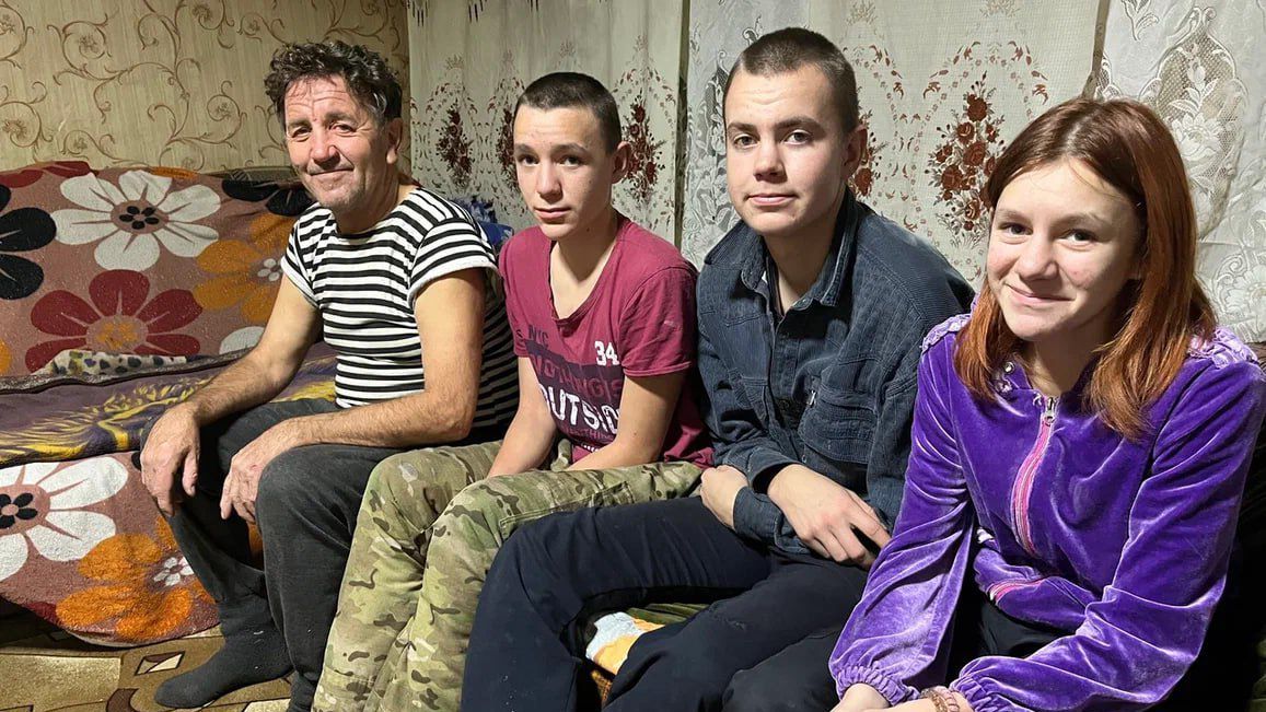 Дедушка с внуками в комнате на диване