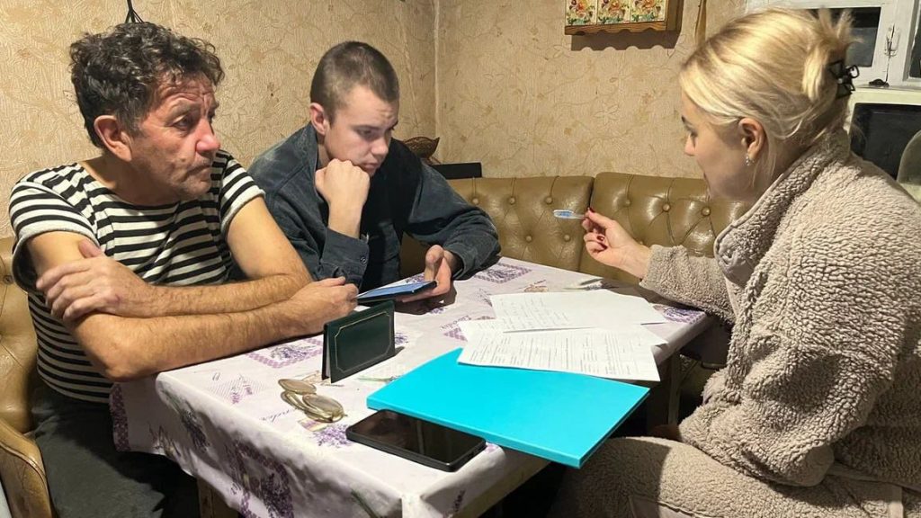 Дедушка с внуком оформляют документы за столом