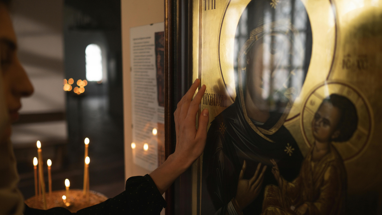 Женщина смотрит на икону Богородицы