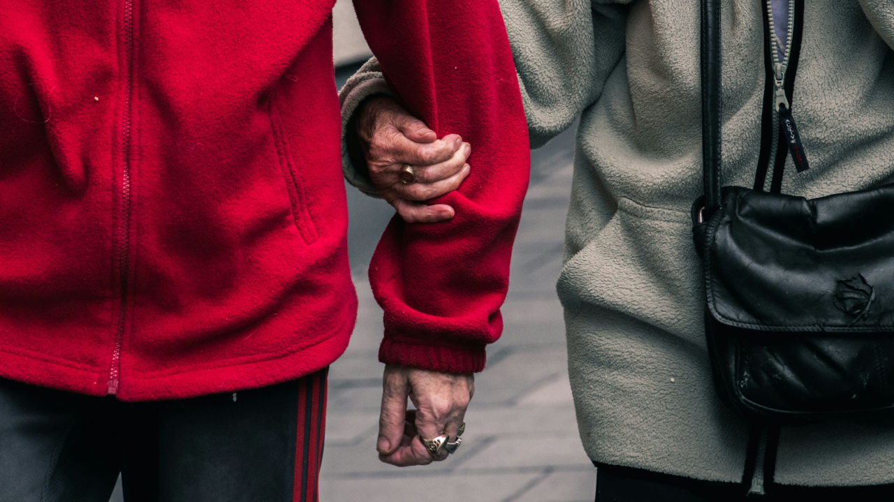 Пожилая женщина держит под руку молодого человека на прогулке