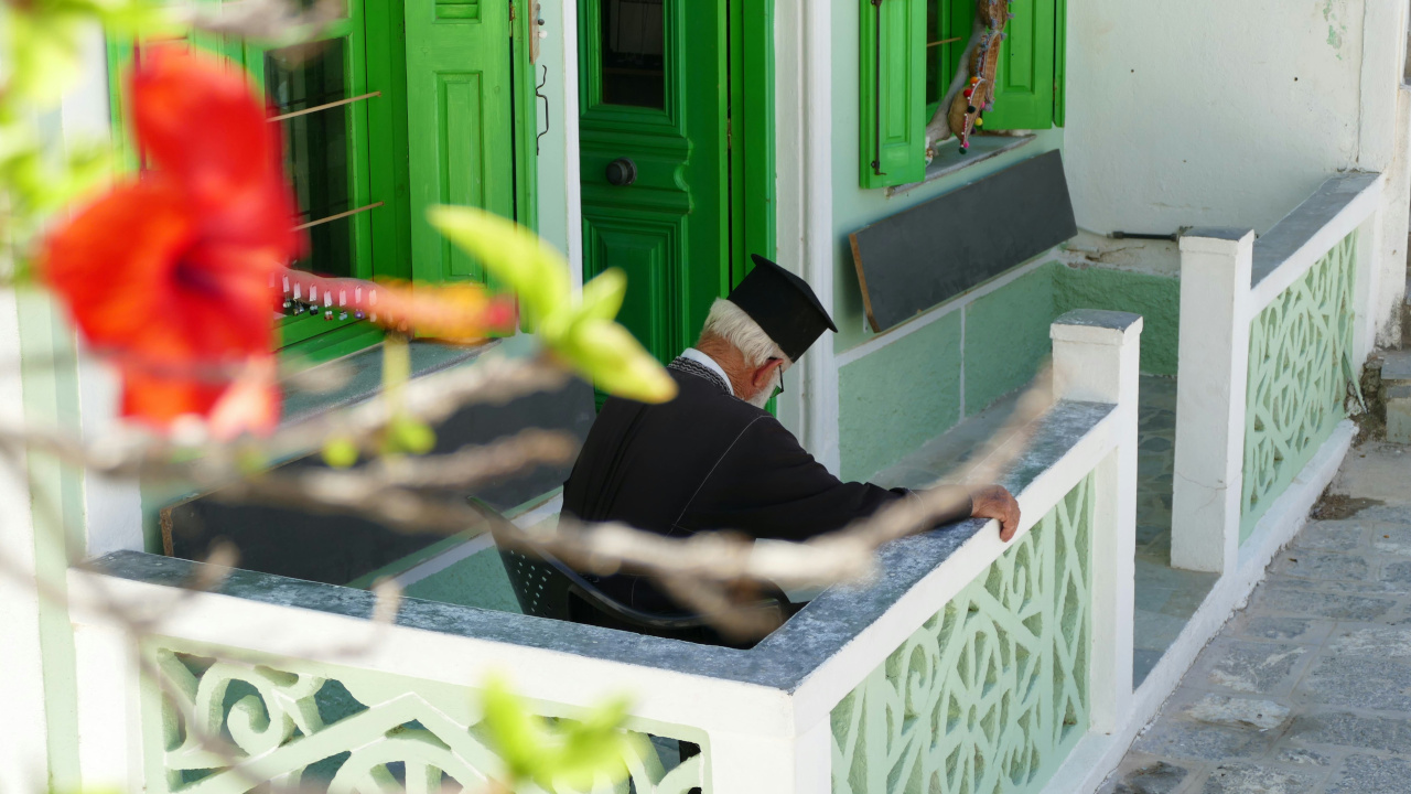 Греческий монах отдыхает на крыльце