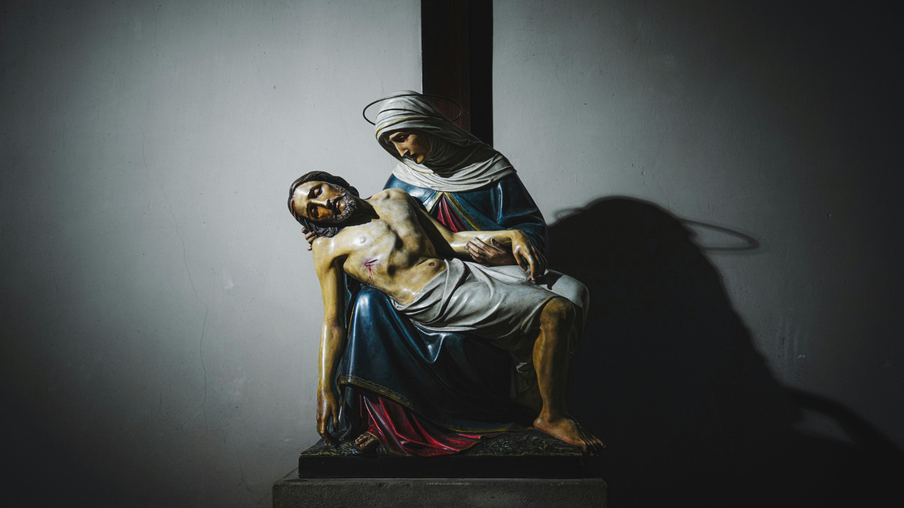 На изображении представлена репродукция скульптуры «Пьета». Это произведение изображает Деву Марию, держащую на коленях тело Иисуса Христа после снятия с креста.