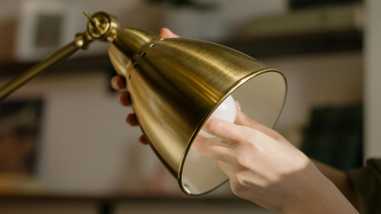 Выкручивают лампу из настольного светильника