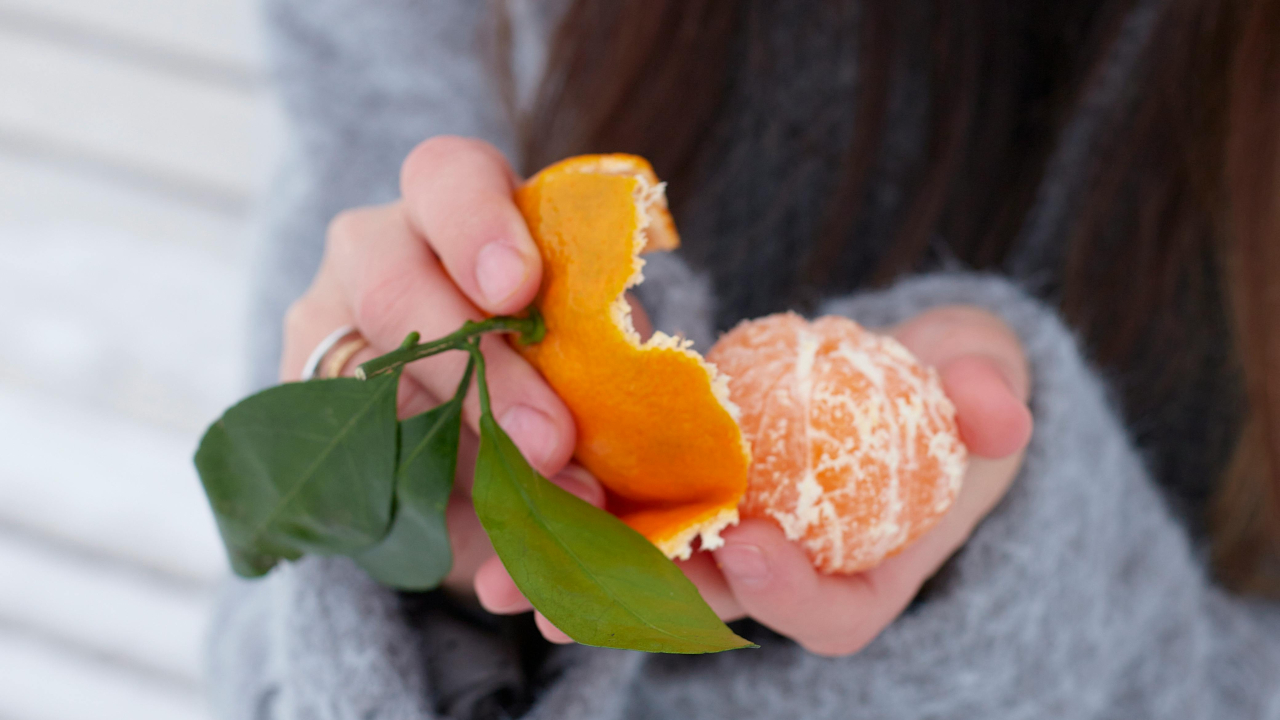 Очищенный мандарин в ладонях