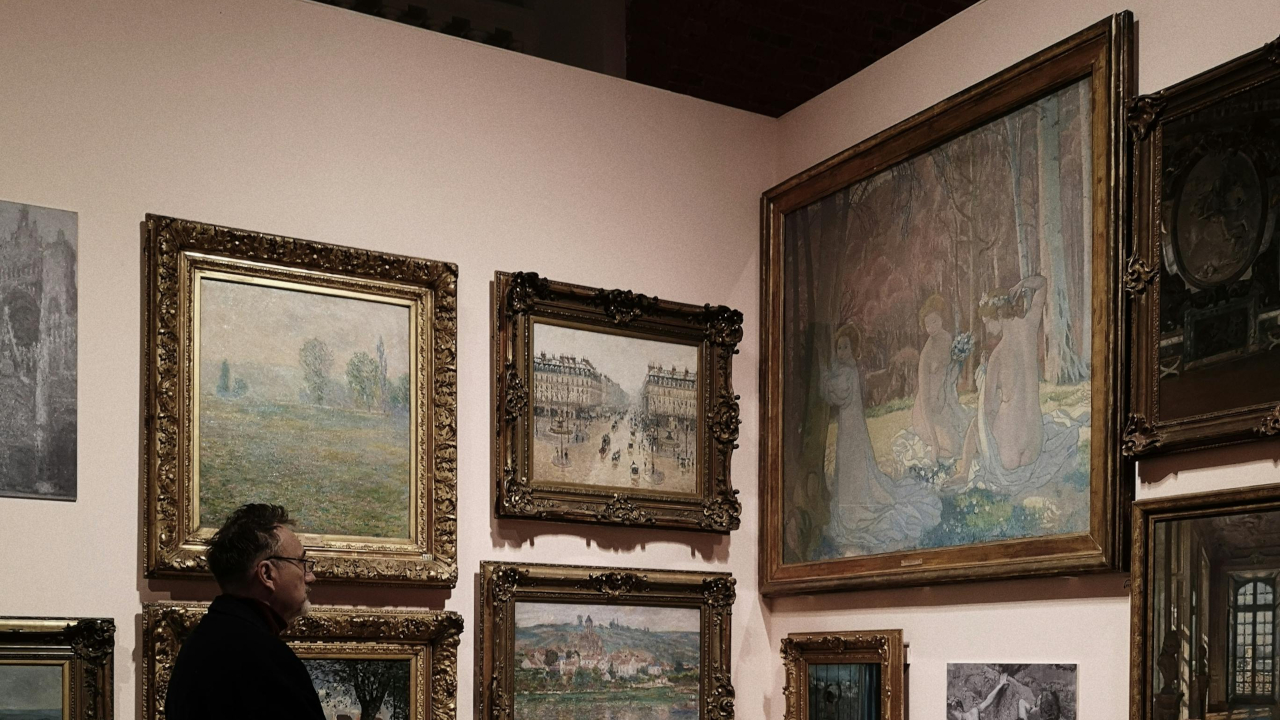 Мужчина рассматривает картины в музее